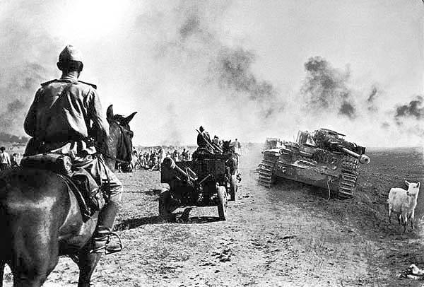 foto WWII Russian troops moving by the road near dead panzer